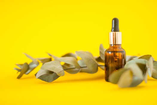 Cosmetic bottles with serum on a bright yellow background. Cosmetology and beauty concept.