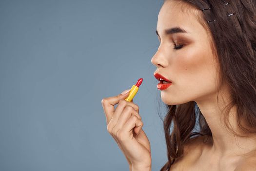 Woman with lipstick on a gray background brunette makeup with eye shadow on the eyelids. High quality photo