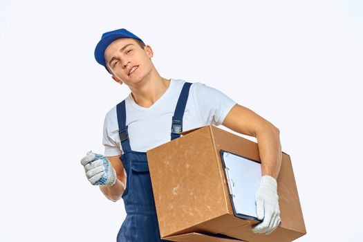 Man worker with box in hands delivery loading service work light background. High quality photo