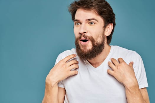 emotional man gesturing with hands lifestyle fun white t-shirt blue isolated stock. High quality photo