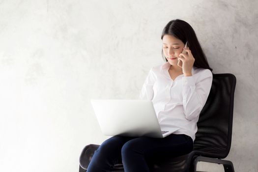 Beautiful asian young businesswoman excited and glad of success with laptop, girl taking mobile phone and working coffee shop on cement background, career freelance business concept.