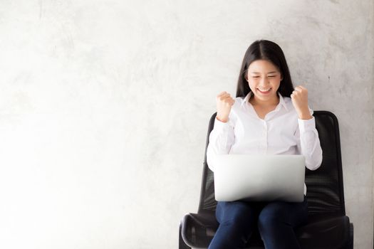 Beautiful asian young woman excited and glad of success with laptop, girl working coffee shop on cement background, career freelance business concept.