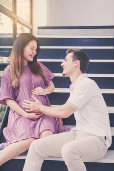 man is listen pregnant of wife, asian handsome father take care mother with couple and expect maternity have a happy, love of family concept.