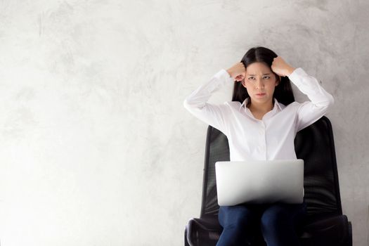 Beautiful young asian woman working and thinking with problem to stress and unhappy, businesswoman with laptop computer on cement background with emotion, freelance business concept.