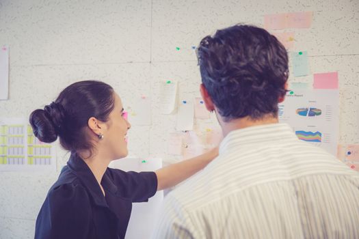 young businesswoman with present profit and secretary while giving presentation in office and talking business people other, teamwork concept.