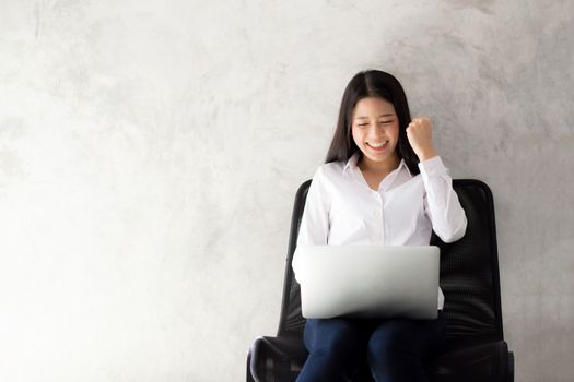 Beautiful asian young woman excited and glad of success with laptop, girl working coffee shop on cement background, career freelance business concept.