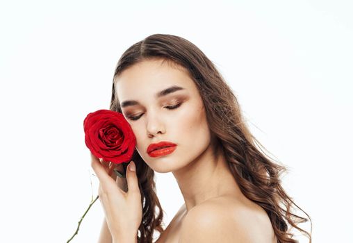 Woman with red flower near face clean skin cosmetology model. High quality photo