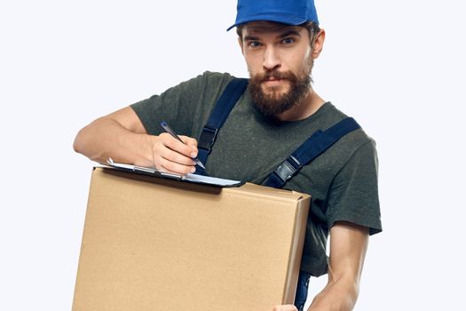 Working male courier with box in hand documents delivery service light background. High quality photo