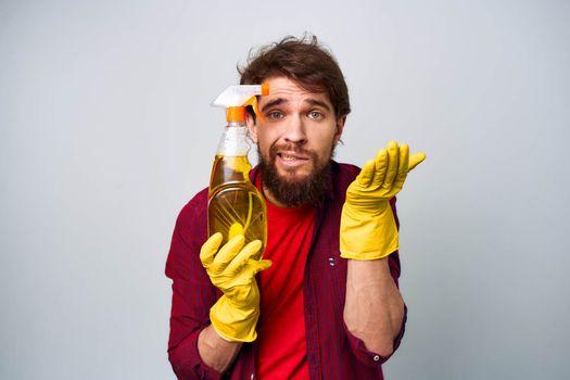 Man in yellow gloves detergent cleaning professional cropped view . High quality photo