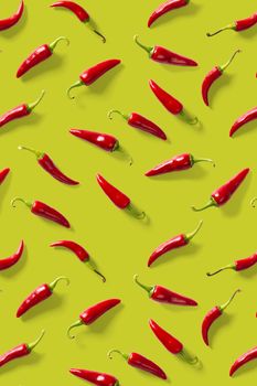 Creative background made of red chili or chilli on green backdrop. Minimal food backgroud. Red hot chilli peppers background, not pattern