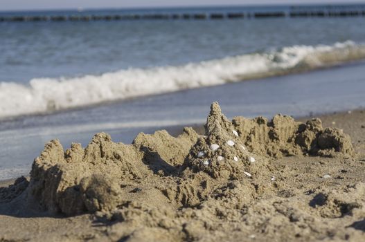 Waves and sand castle on the Baltic Sea beach