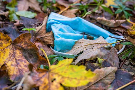 Discarded Corona mask Garbage in the dirt in colorful autumn leaves in Germany Garbage problem