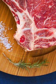 Raw beef meat on the table, spices and Rosemary, Rib eye steak ingredients. Pepper and coarse salt