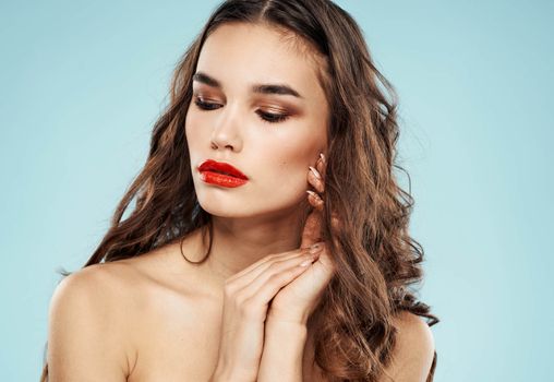 Charming lady red lips brunette blue background makeup model. High quality photo