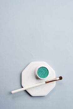Green eyeshadow and makeup brush on white stand isolated background. High quality photo