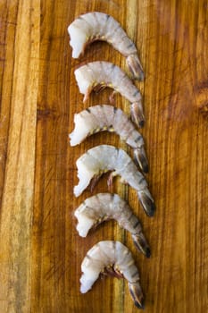 Raw shrimps on the wooden board, natural light.