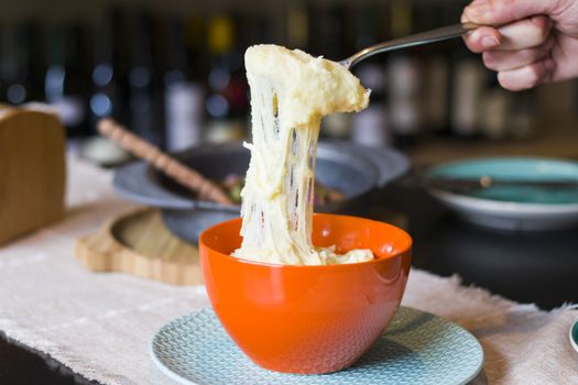 Georgian traditional dish with potatoes and cheese, Tashmijabi. Human hand, cooking process.