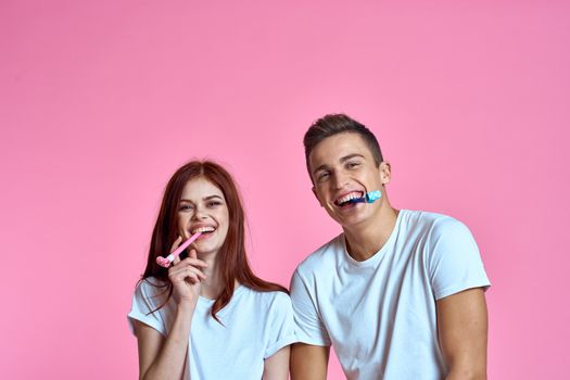 enamored man and woman hugging each other on a pink background cropped with Copy Space family portrait. High quality photo