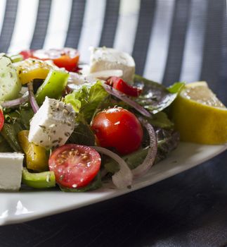 Vegetarian salad with tomatoes, cheese,vegetables and green salad. Studio shot.