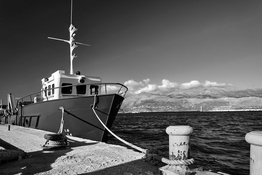 A fishing vessel moored in the port of Lixouri on the island of Kefalonia, Greece, monochrome