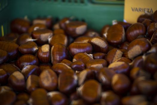 brown chestnuts in a box for sale at the market