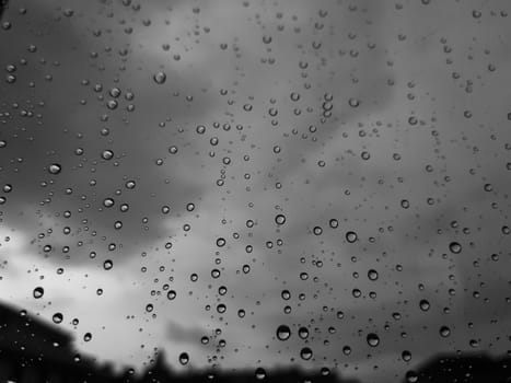 Genova, Italy - 10/22/2020: Water​ rain​ drops​ on​ glass​ background.​ Rain​ drops​ on​ a​ Windows. Hdden sunset in autumn after rain.