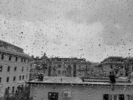 Genova, Italy - 10/22/2020: Water​ rain​ drops​ on​ glass​ background.​ Rain​ drops​ on​ a​ Windows. Hdden sunset in autumn after rain.