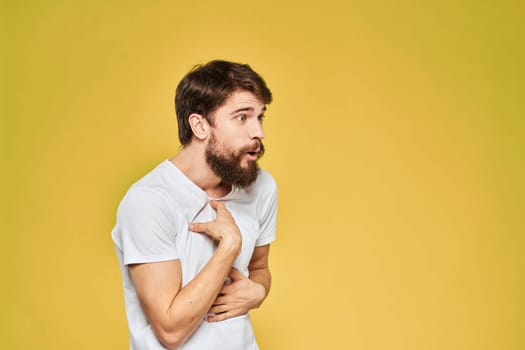 Bearded man in white t-shirt emotions close-up fun yellow background. High quality photo