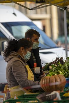 terni,italy october 23 2020:walking man and woman at the market selling vegetables