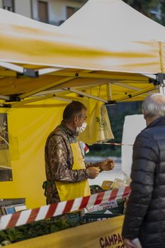 terni,italy october 23 2020:walking man with medical mask at the market selling vegetables