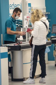 terni,italy october 23 2020:man at the shop checkout with customer paying the bill