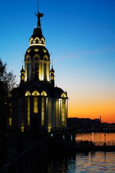 Christian temple by the water at sunset.