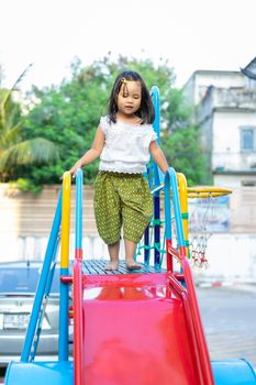 asian little girl in Thai period dress playing in a children playground