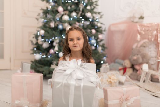 Happy childhood, magical Christmas tale. Little princess with Santa's present for Christmas.