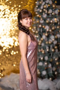 Stylish beautiful girl among sparkles and gerlands at a Christmas party.