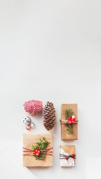 Christmas DIY presents wrapped in craft paper with fir tree twigs and red hearts. Top view on decorations on New Year gifts. Festive background. Winter holiday spirit. Banner with copy space.