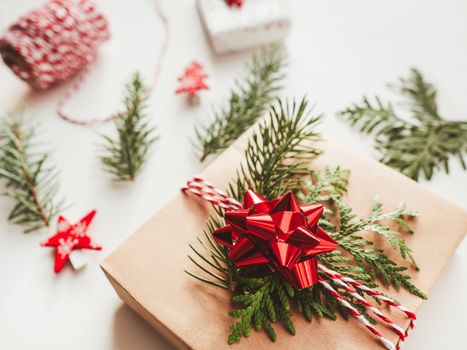 Christmas DIY presents wrapped in craft paper with fir tree branches and red bow. Decorations on New Year gifts. Festive background. Winter holiday spirit.