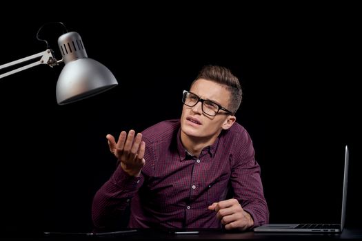 Male manager indoors dark background communication red shirt model glasses new technologies business finance. High quality photo