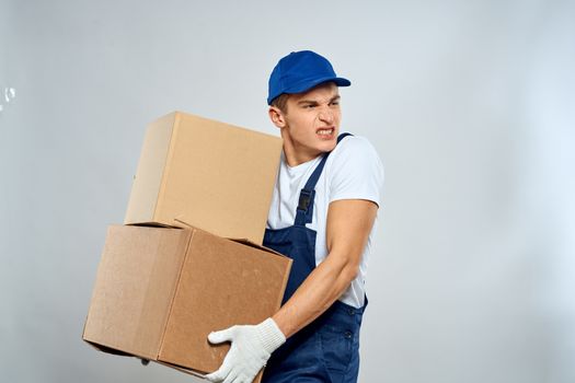 working man in uniform with boxes in his hands delivery loader lifestyle. High quality photo