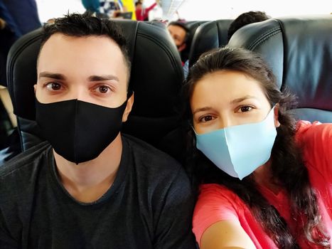 couple of travelers wearing masks on their faces in the cabin. Flights under the new rules of the coronavirus pandemic.