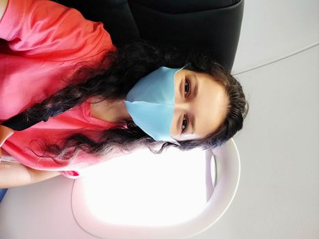 A girl in a mask makes a selfie in the cabin of the plane. flights under the new rules coronavirus.