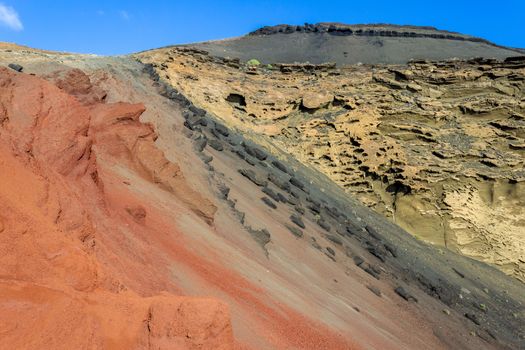 Volcanic mountain in different red, black and beige colours nearby El Golfo on canary island Lanzarote, Spain