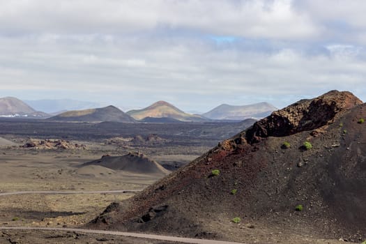 View at multi colored volcanic landscape in Timanfaya Nationalpark on canary island Lanzarote, Spain 