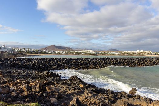 Lava rocks, rough sea and water waves at the coastline of Costa Teguise on Canary island Lanzarote, Spain