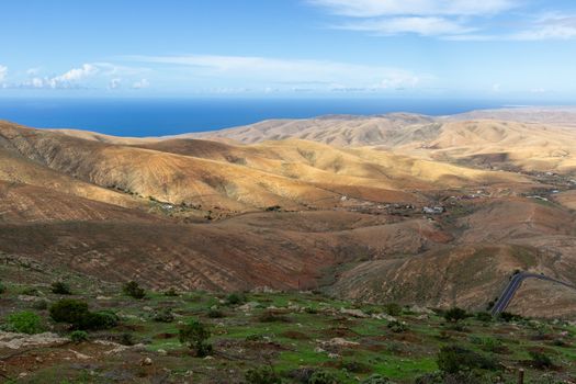 Panoramic view at landscape from viewpoint Mirador Morro Velosa on Fuerteventura, Spain with  green vegetation and multi colored volcanic hills