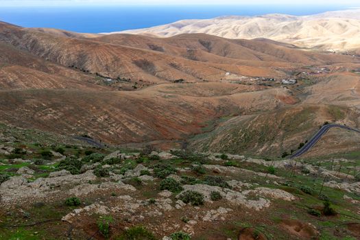 Panoramic view at landscape from viewpoint Mirador Morro Velosa on Fuerteventura, Spain with  green vegetation and multi colored volcanic hills