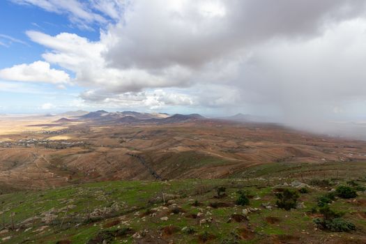 Panoramic view at landscape from viewpoint Mirador Morro Velosa on Fuerteventura, Spain with  green vegetation and multi colored volcanic hills