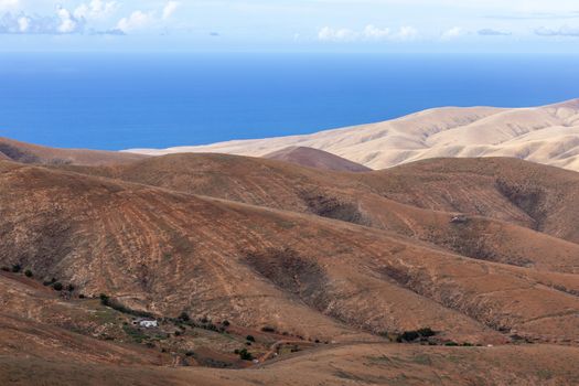 Panoramic view at landscape from viewpoint Mirador Morro Velosa on Fuerteventura, Spain with  multi colored volcanic mountainss and the Atlantic ocean in the background