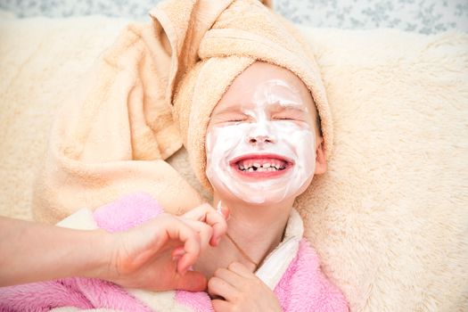 Portrait of young girl doing doing spa treatments in the bedroom.