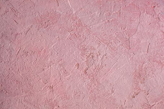 Concrete pink background with scuffs and splashes. Textured wall texture in the grunge style with soft focus. Space for text